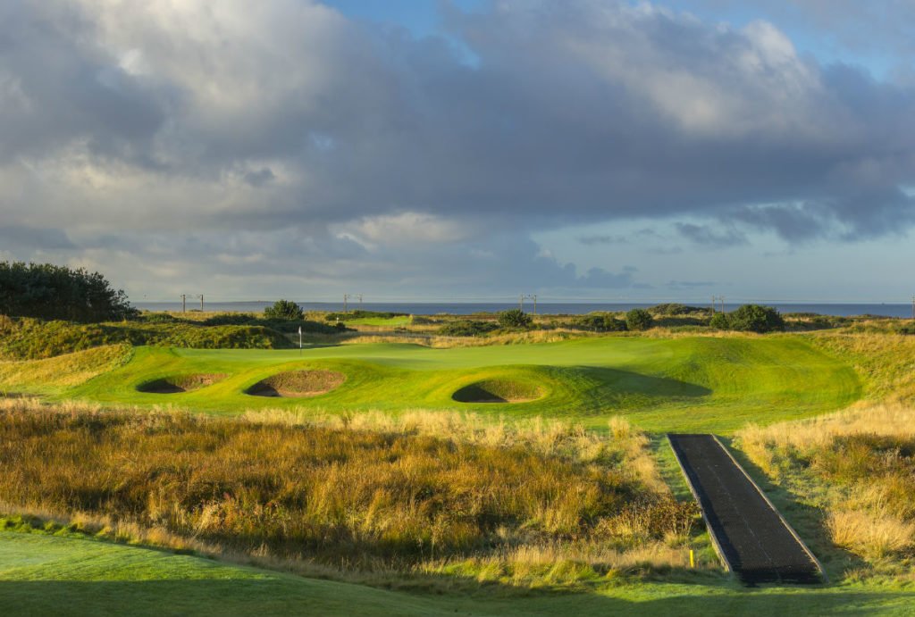 Dundonald Links 11th hole in Ayshire, Scotland. Golf green surrounded by 3 bunkers
